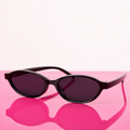 Black sunglasses with dark lenses on a pink surface